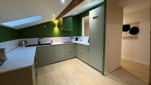 A modern kitchen with green cabinets, a white countertop, and a skylight. - LYON PRESQU ILE musée des tissus - Air-conditioned APARTMENT ideal for visiting LYON (Lyon)