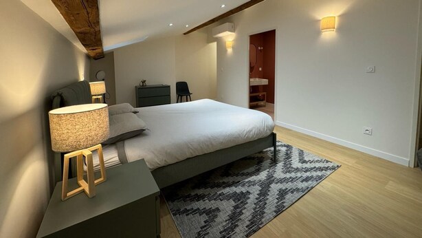 A modern bedroom with a skylight, a bed, a bedside table with a lamp, a dresser, and a chair. - LYON PRESQU ILE musée des tissus - Air-conditioned APARTMENT ideal for visiting LYON (Lyon)