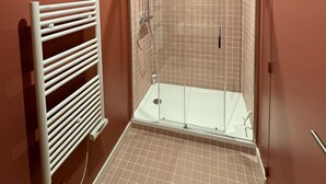 A small, enclosed shower area with a glass door, a white towel rack, and a tiled floor. - LYON PRESQU ILE musée des tissus - Air-conditioned APARTMENT ideal for visiting LYON (Lyon)