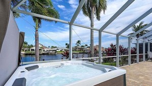 A hot tub with a view of a marina and palm trees.