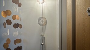 A room with a door, a wall-mounted light fixture, and a power outlet. - Studio Cosy et Tout Confort à Proximité Immédiate du Canal ! Cœur de Paris (Paris)