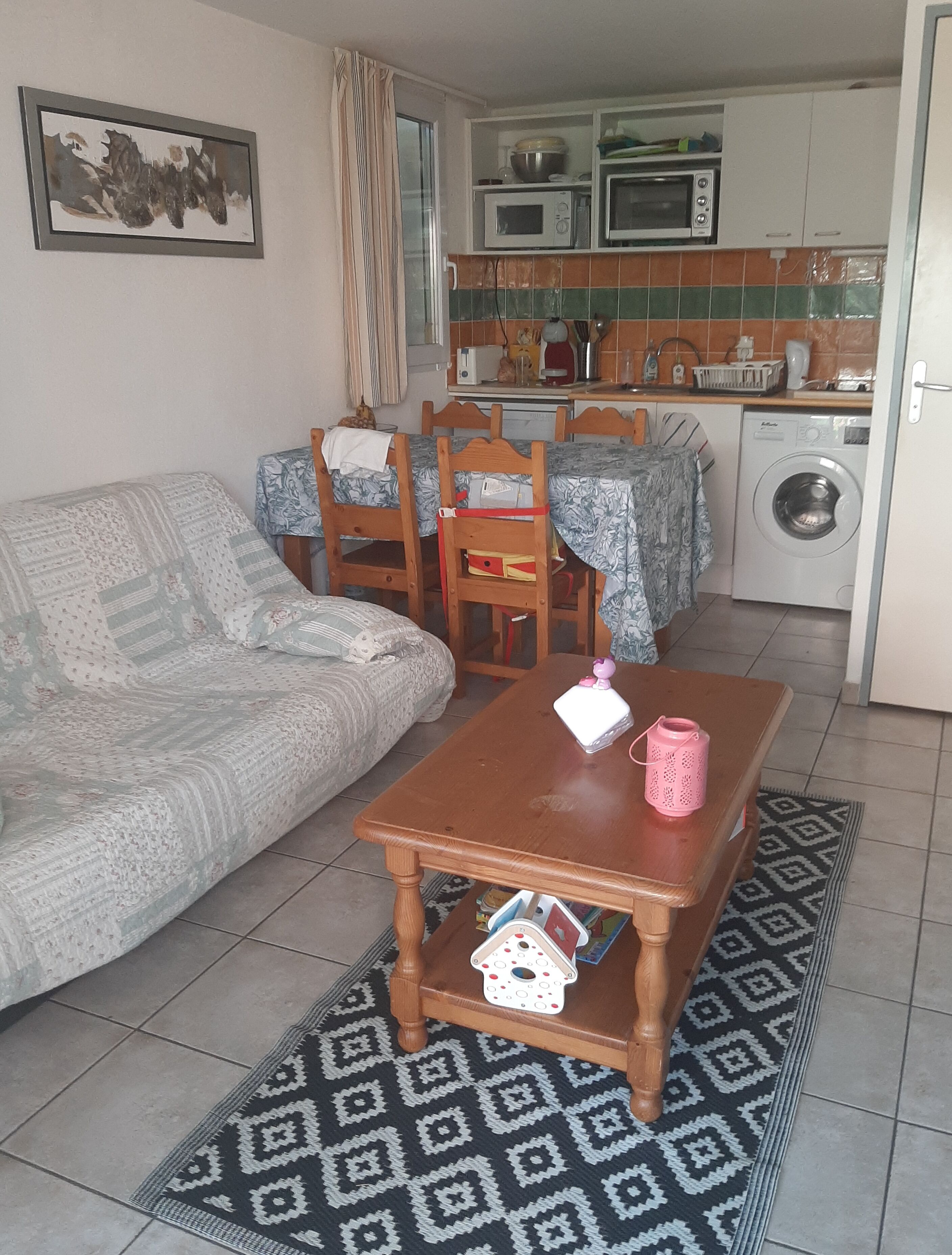 A living room with a sofa, a wooden coffee table, and a patterned rug.