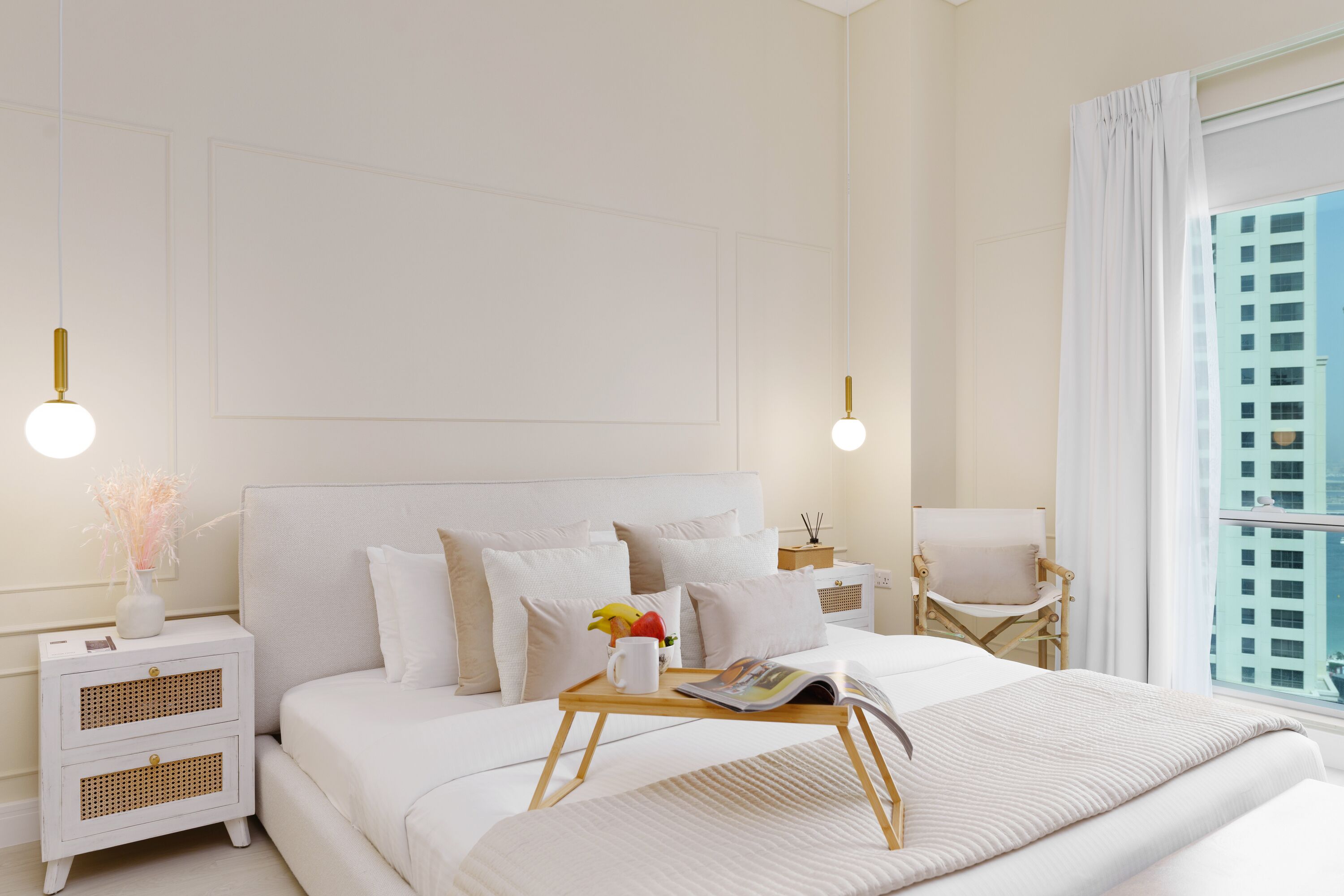 A modern bedroom with a large bed, bedside tables, and a view of a cityscape.