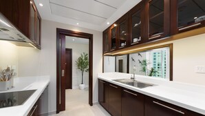 A modern kitchen with dark wooden cabinets, a white countertop, and a built-in sink. - Maison Privee - Modern Beach Living in the Heart of Dubai Marina (Dubai)