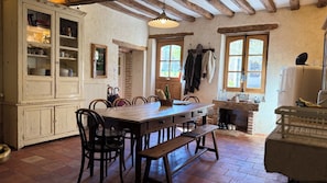 A rustic kitchen with a wooden table, chairs, and a brick fireplace. - Authentic Large Property in the Heart of Perche, Peacefull Location, Pool, Park (Longny les Villages)