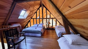 A cozy attic bedroom with a sloped ceiling, wooden walls, a bed, a chair, and a small table. - Authentic Large Property in the Heart of Perche, Peacefull Location, Pool, Park (Longny les Villages)