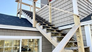A residential building with a wooden staircase leading to a second floor. - 2 bedroom w/ expansive water views (Phippsburg)