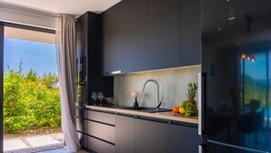 Une cuisine moderne dotée d’une grande fenêtre, d’un évier et d’un réfrigérateur.
