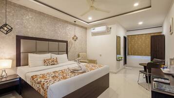 Une chambre d’hôtel moderne dotée d’un grand lit, d’un bureau avec une chaise, d’un ventilateur de plafond et d’un appareil de climatisation.