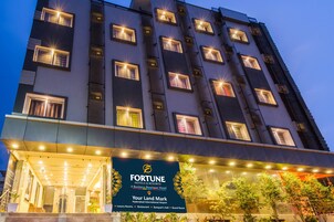 Un hotel de varios pisos con ventanas iluminadas y un cartel de Fortune Hotels & Resorts.