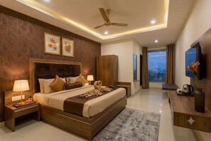 A modern hotel room with a large bed, a flat-screen TV, a ceiling fan, and a city view. - Hotel Fortune Hyderabad Airport Zone (Hyderabad)