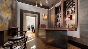 A bar area with a wooden floor, a counter with bottles, and a wall with a light fixture. - Westwell Hall, large coastal house sleeping up to 29 (Ilfracombe)