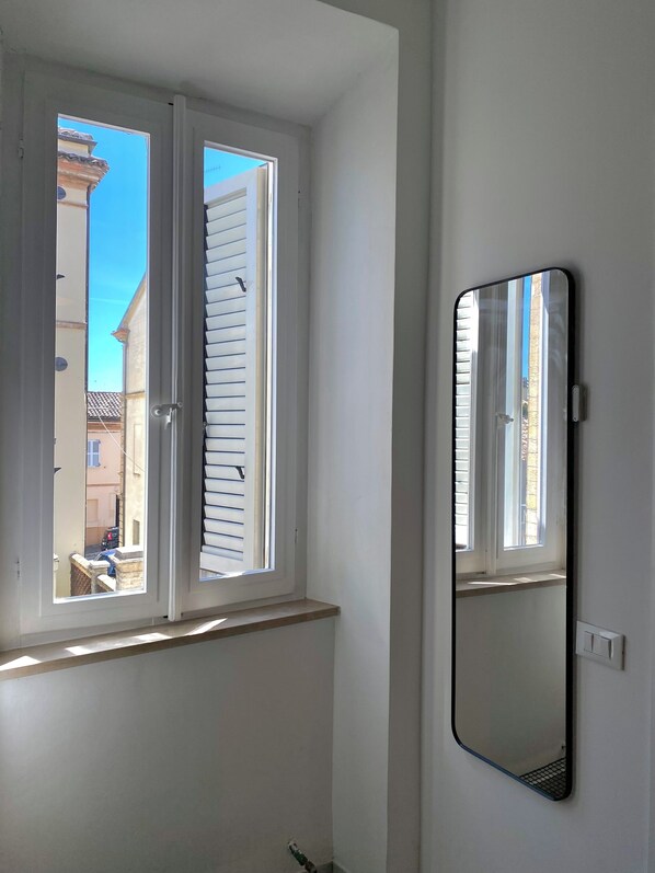 Une pièce avec une fenêtre et un miroir.