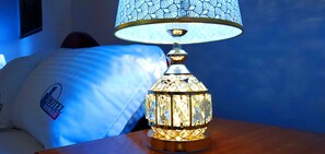 A decorative lamp with a patterned shade and a metallic base, placed on a wooden surface. - Hotel Komar (Lira)