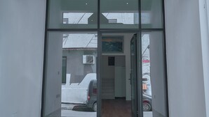 The entrance to a hotel with a sign reading "Kalpazo Inn" above the glass doors.