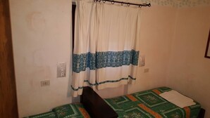 A small, single-bed room with a curtain and a patterned bedspread. - THREE-ROOM APARTMENT RESIDENCE WITH SWIMMING POOL IN EXCLUSIVE AREA AND NEAR THE SEA (Porto Cervo)