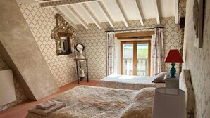 Un dormitorio con dos camas, un espejo, una lámpara y una ventana con cortinas.