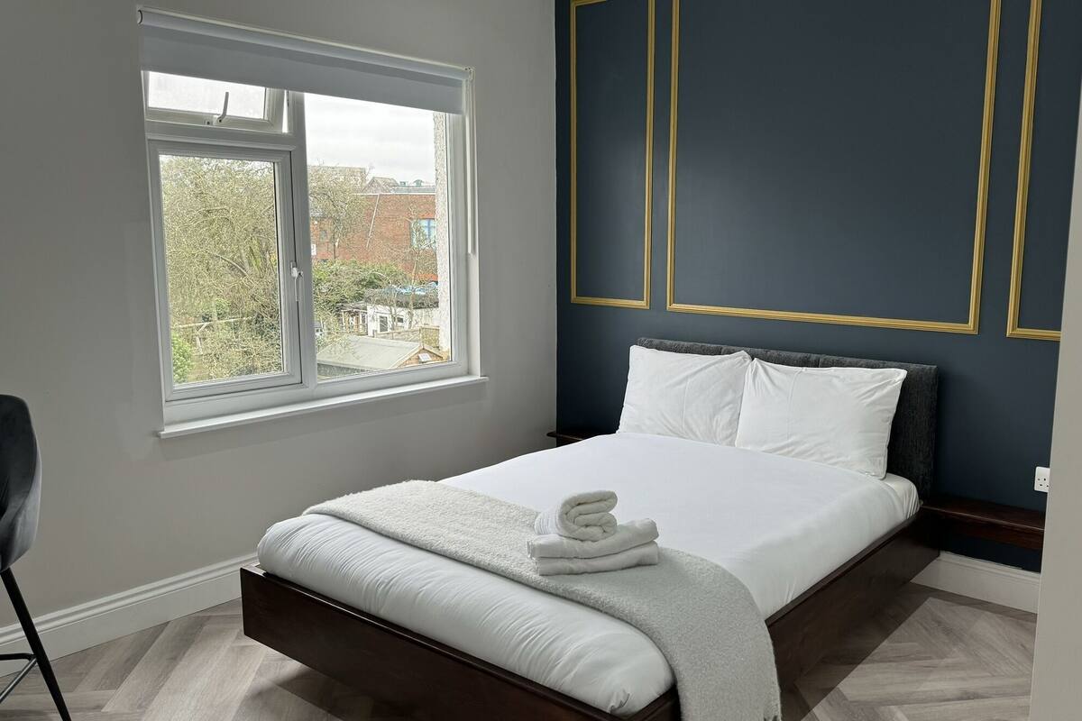 A bedroom with a bed, a window, and a view of the outside.