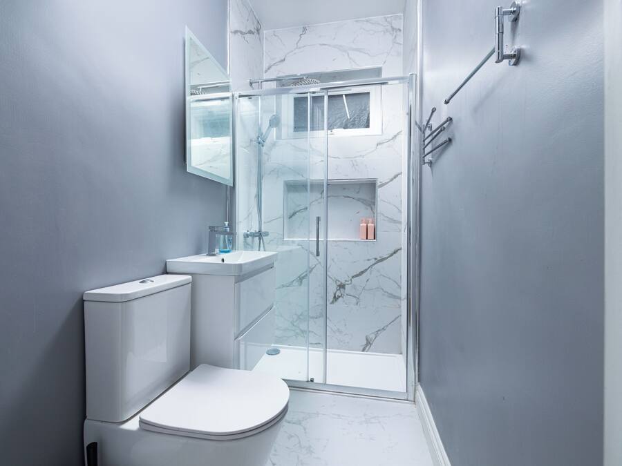 A modern bathroom with a toilet, sink, and glass-enclosed shower.