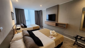 A hotel room with two beds, a TV, a desk, and a window with curtains. - Amerian Rio Cuarto (Rio Cuarto)
