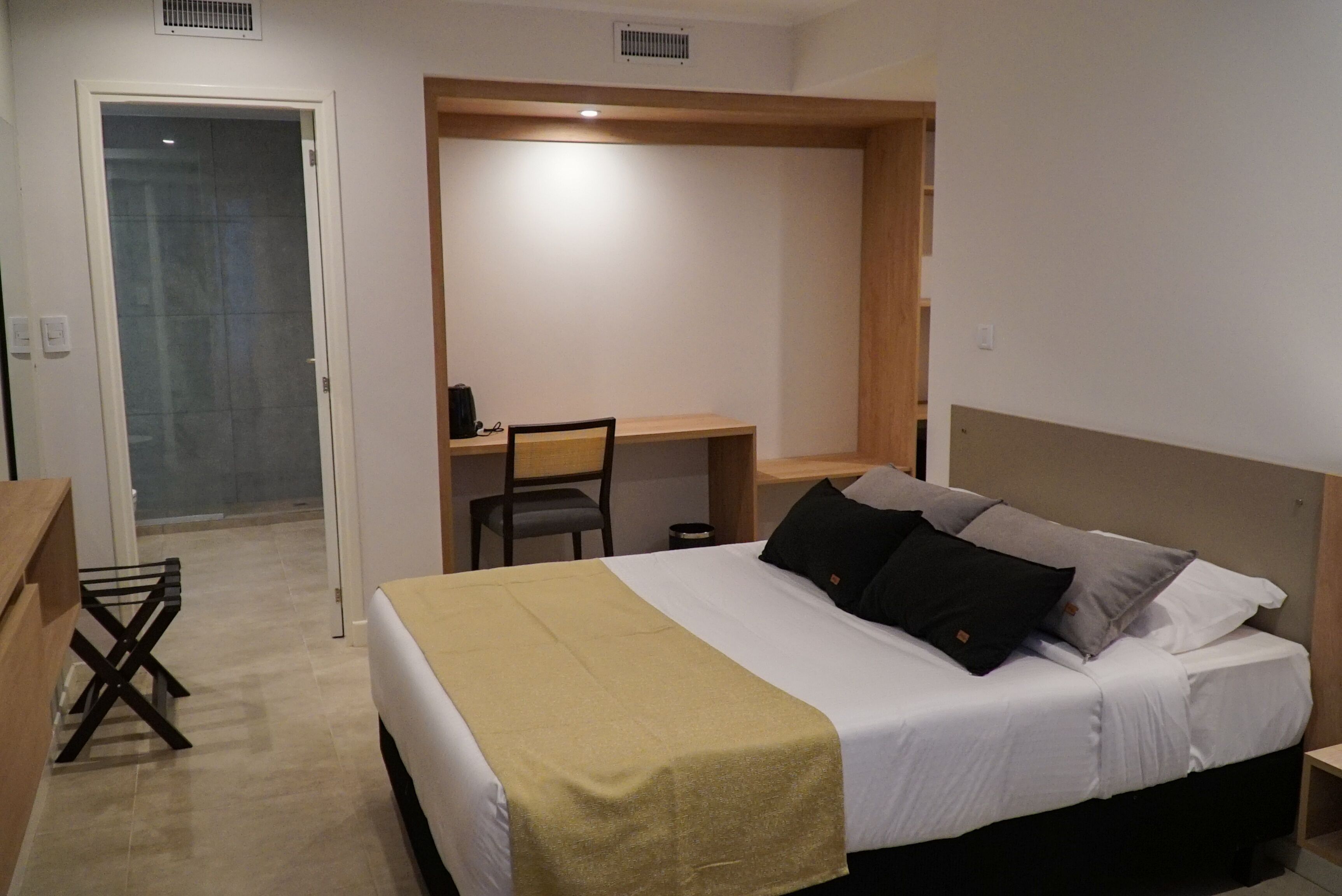 A bedroom with a bed, a desk, and a chair.