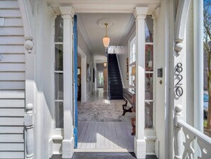 Step into a grand entrance with a covered porch and elegant staircase.