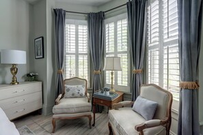 Classic design room with two comfortable chairs, a dresser, and a picture on the wall.