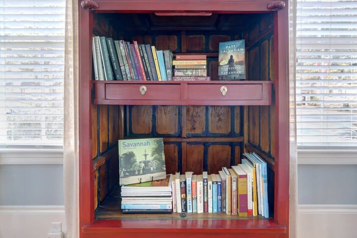 Ein Bücherregal mit Büchern, darunter Titel wie 'Savannah' und 'The Secret of Happy Endings'.