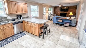 A spacious kitchen with wooden cabinets, a granite countertop, and a built-in dishwasher.