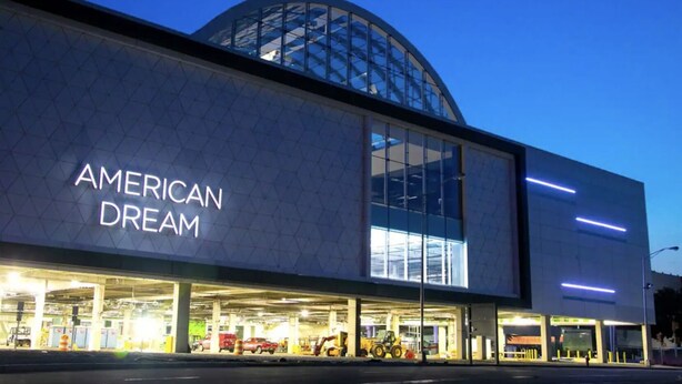 Ein modernes Gebäude mit großer Glasfassade und der Aufschrift "AMERICAN DREAM" an der Seite.