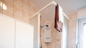 A shower area with a glass door, a white cabinet with drawers, and a towel hanging on the door. - 2 bedrooms apartment Anita with BBQ (Pula)