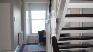Een trap met witte balustrades en donkerhouten treden die uitkomen op een plateau.