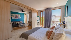Een moderne slaapkamer met een groot bed, een bureau en uitzicht.
