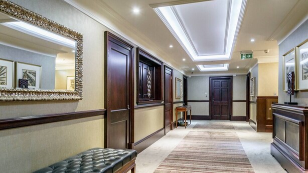 A hotel hallway with a bench, doors, a mirror, and a ceiling with skylights. - Cathedral Quarter | City Centre | Walk Everywhere - Pass the Keys (Belfast)