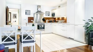 A modern kitchen with white cabinetry, a stainless steel range hood, and a built-in oven. - Cathedral Quarter | City Centre | Walk Everywhere - Pass the Keys (Belfast)