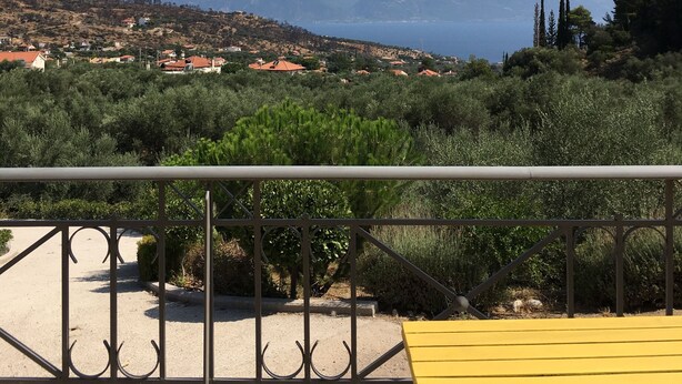 A balcony with a metal railing and a yellow bench. - A beautiful olive orchard with mountain and sea view,ideal for a relaxing break  (Ziria)