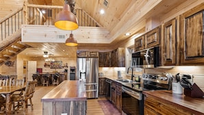 Une cuisine spacieuse dotée de meubles en bois, d’appareils électroménagers en acier inoxydable et d’un coin repas en bois.