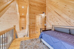 A wooden interior with a bed, a staircase, and a door leading to another room. - Outdoor Fireplace * Mountain Views * Hot Tub * (Mineral Bluff)