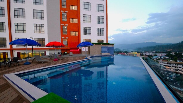 Una piscina amb terrassa de fusta, gandules i ombrel·les.
