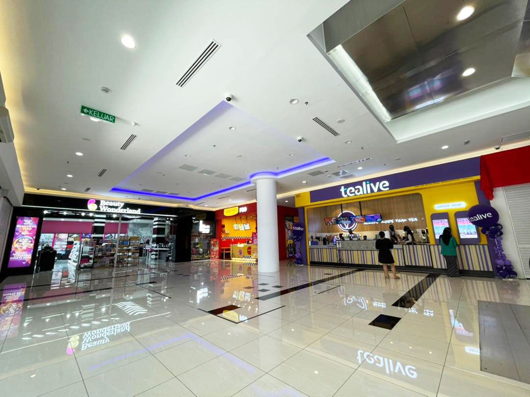 A modern shopping mall interior with a 'tealive' store, a 'Beauty Wonderland' store, and a 'KELUAR' sign.