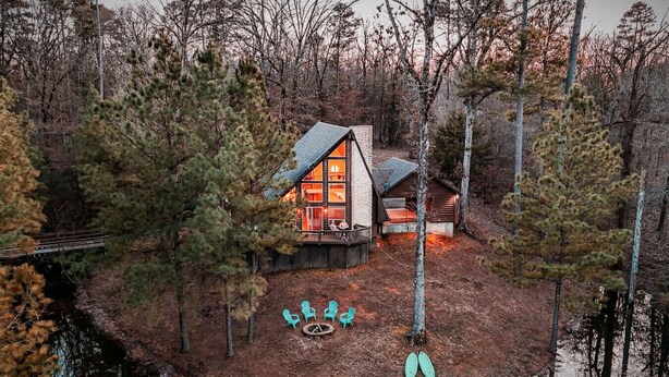 Una cabaña en una isla junto al lago, con terraza, mobiliario exterior y una zona para hacer fuego.