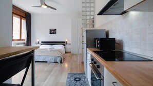 Una cocina compacta con encimera de madera, horno integrado y microondas.