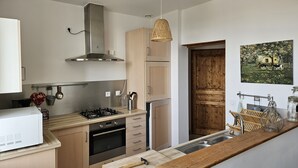 Une cuisine moderne avec des meubles en bois, des appareils en acier inoxydable et un plan de travail en bois.