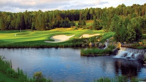 Un parcours de golf avec un étang et une cascade.
