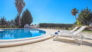 A swimming pool with lounge chairs and palm trees. - Modern apartment near Albufeira centre (Albufeira)