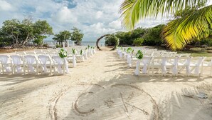 A beach wedding aisle with white chairs and a palm tree arch. - Oceanfront 5 bedroom Hibiscus House Private Villa Beach BEST Pool on the Island (San Pedro)