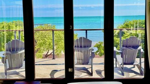 A balcony with two Adirondack chairs facing a view of the ocean. - Oceanfront 5 bedroom Hibiscus House Private Villa Beach BEST Pool on the Island (San Pedro)