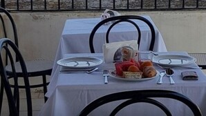 A table set for two with plates, cutlery, and a glass of water.