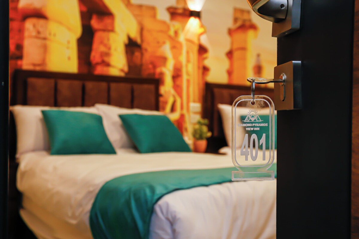 A hotel room with a bed, green pillows, and a sign indicating room number 401.