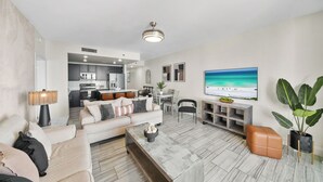 Ein modernes Wohnzimmer mit einer Couch, einem Couchtisch und einem an der Wand montierten Fernseher.